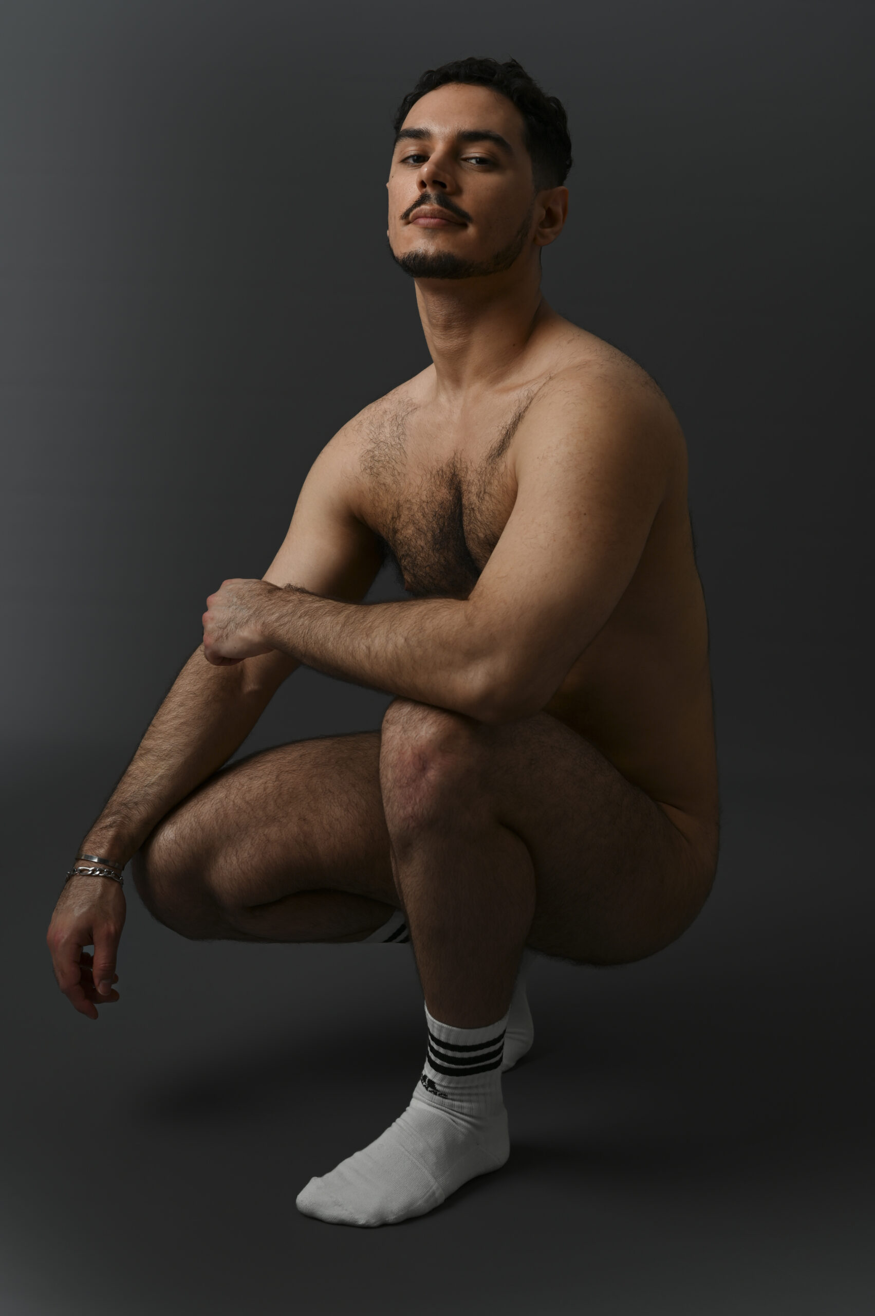 Modèle masculin nu et musclé accroupi