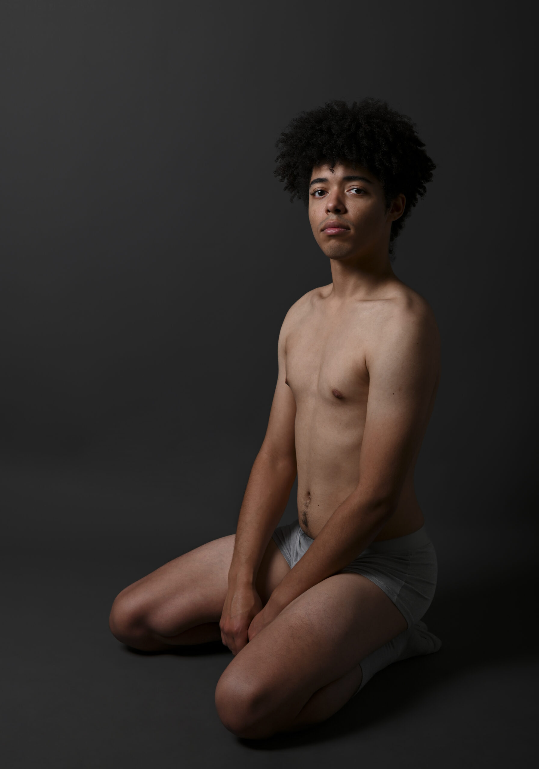 Un modèle masculin en boxer gris à genoux