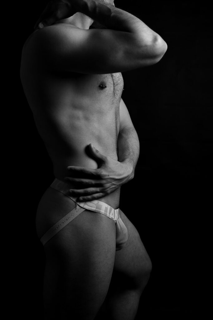 Corps musclé d'un homme en jockstrap pour photo en noir et blanc