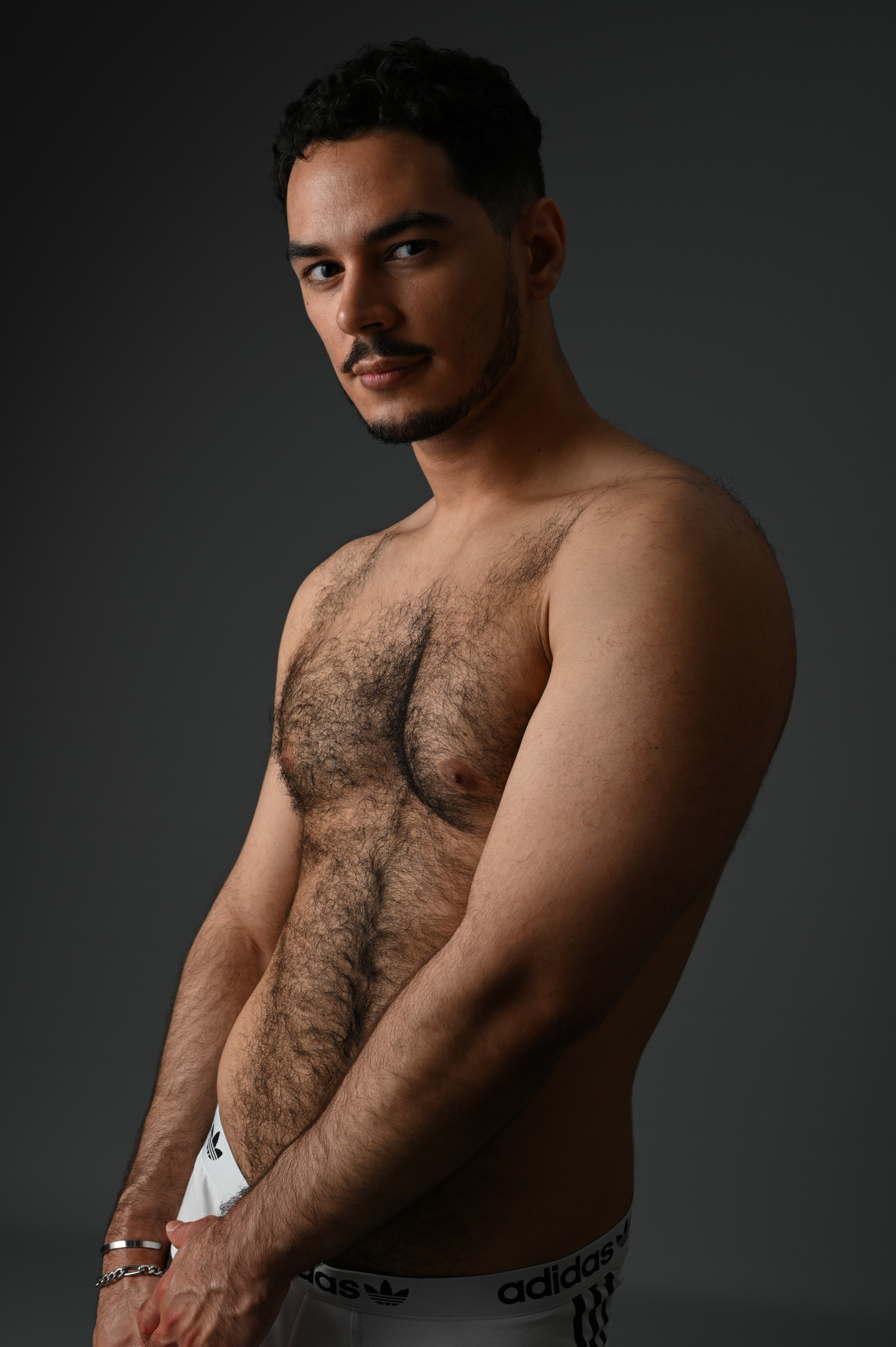 un homme musclé et poilu en boxer qui pose pour un photographe