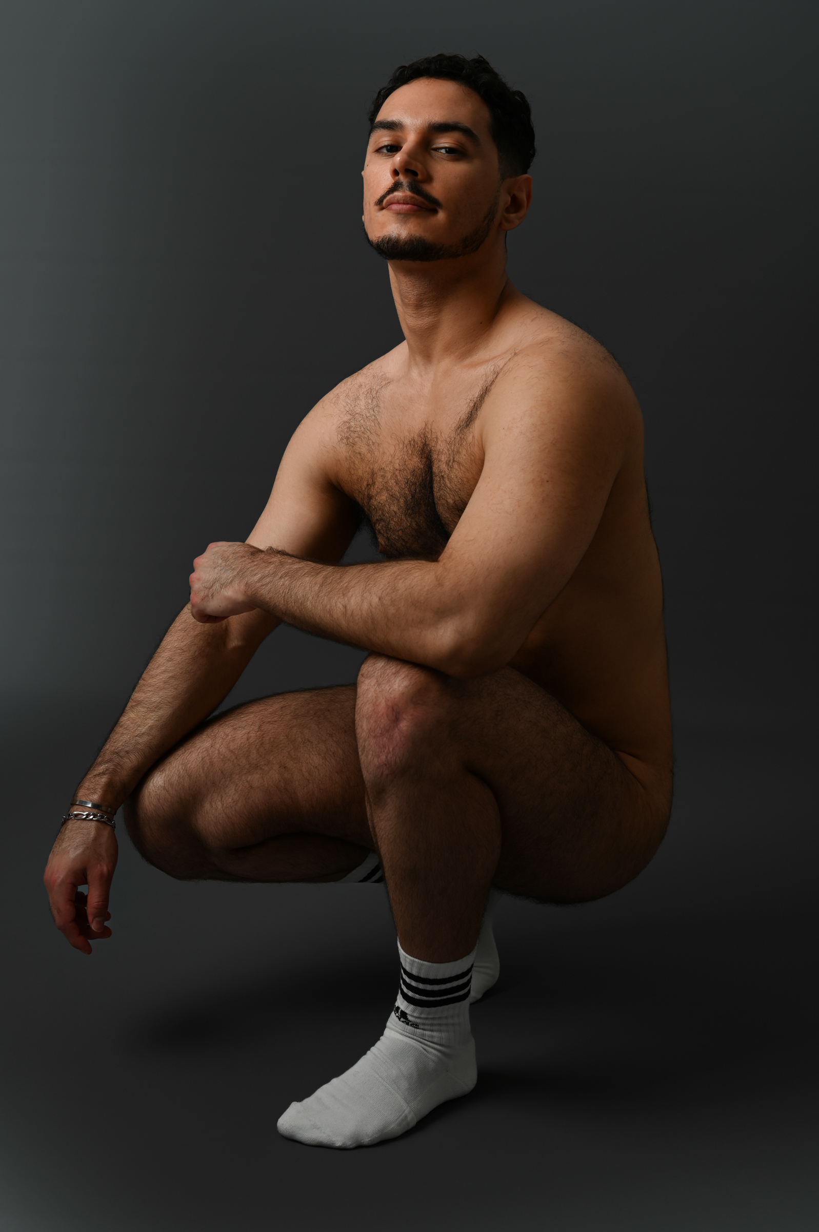 Un homme nu accroupi en chaussette
