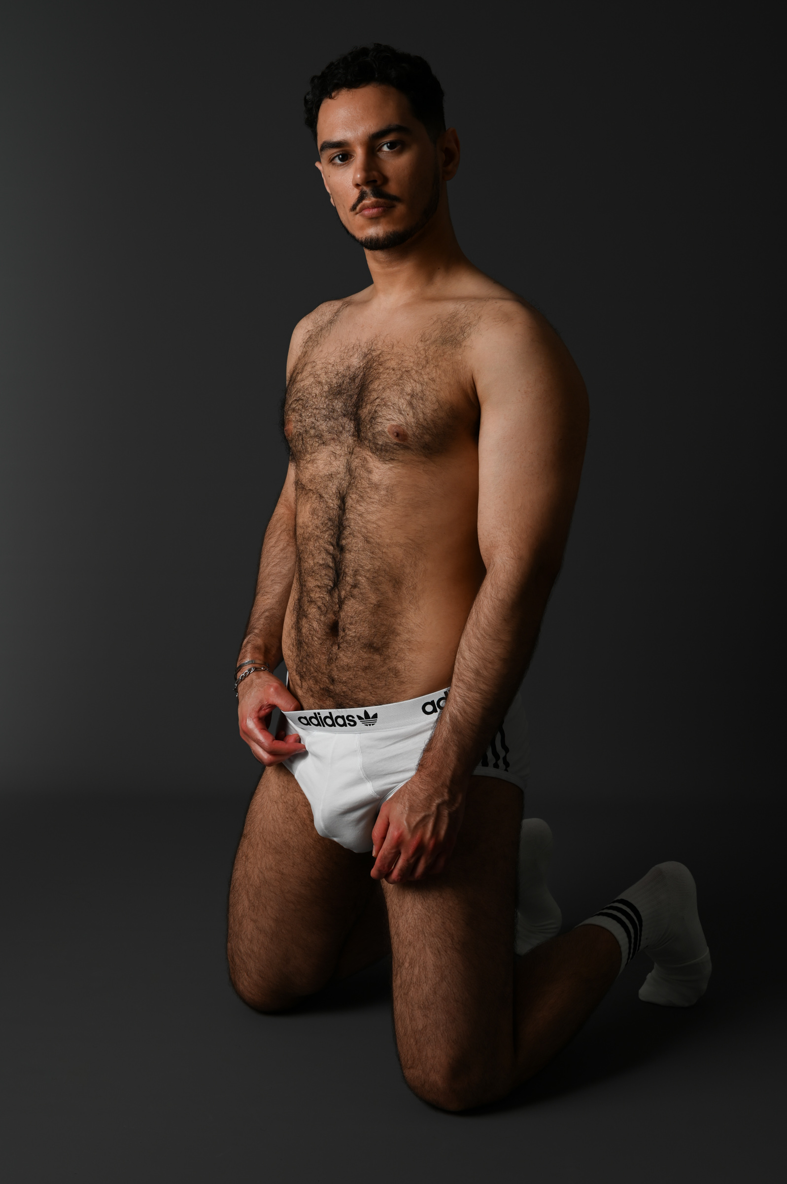 Homme sexy et musclé en boxer à genoux au sol